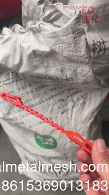 Rote Kunststoff-Support-Clips, die zwischen dem Concertina-Draht und dem Draht gehen